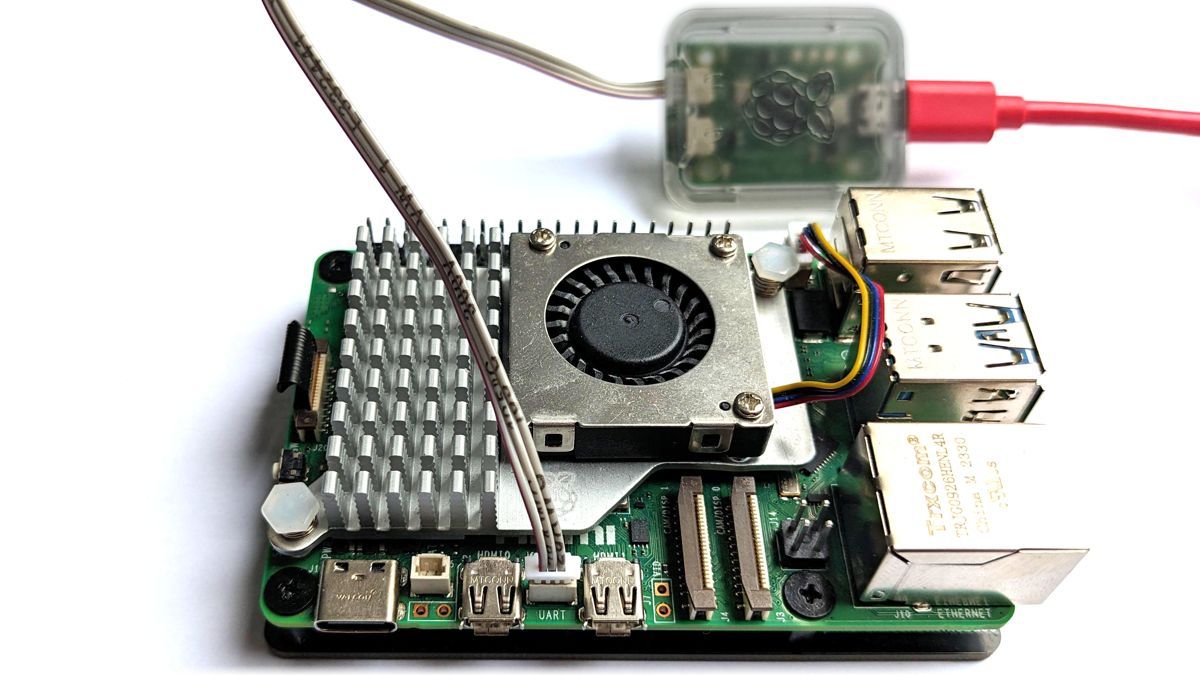 A close-up of the Raspberry Pi debug probe connected to the UART port located between the micro-HDMI ports of a Raspberry Pi 5.