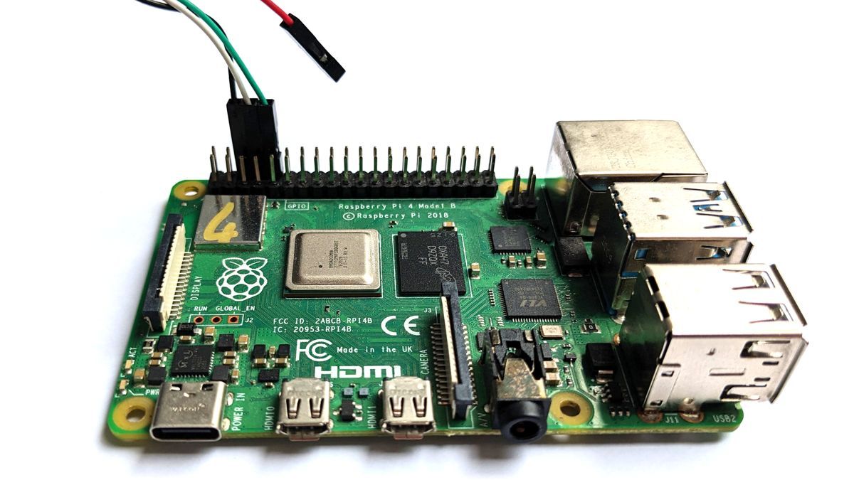 A close-up of a traditional USB UART adapter connected to the UART on the GPIO header of a Raspberry Pi 4B